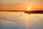 Sailing boats on lake Gooimeer during sunset