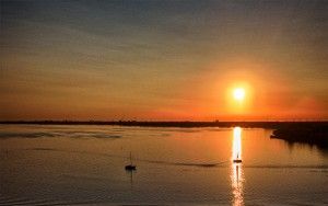 Sailing boats on lake Gooimeer during sunset