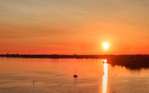 Sailing boats on lake Gooimeer during sunset