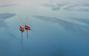 Sailing boats on lake Gooimeer during sunset