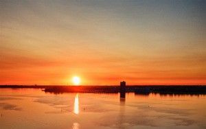 Sailing boats on lake Gooimeer during sunset