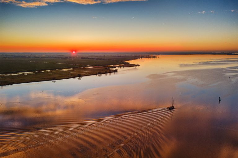 Sunset drone picture of lake Eemmeer, as a boat passes