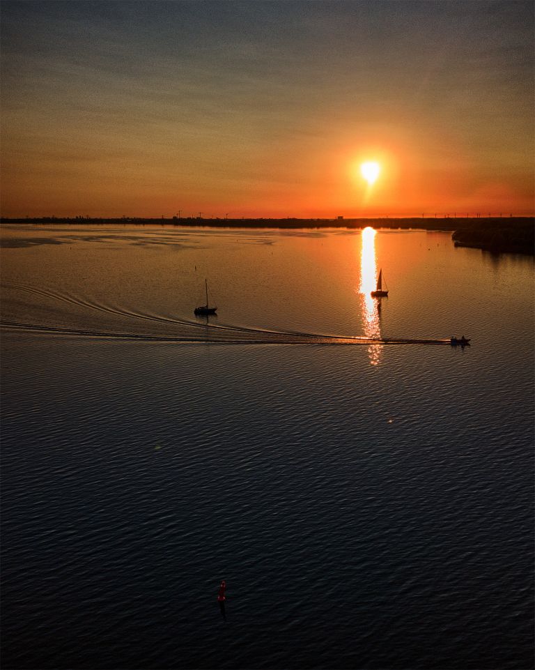 Boats on lake Gooimeer during sunset