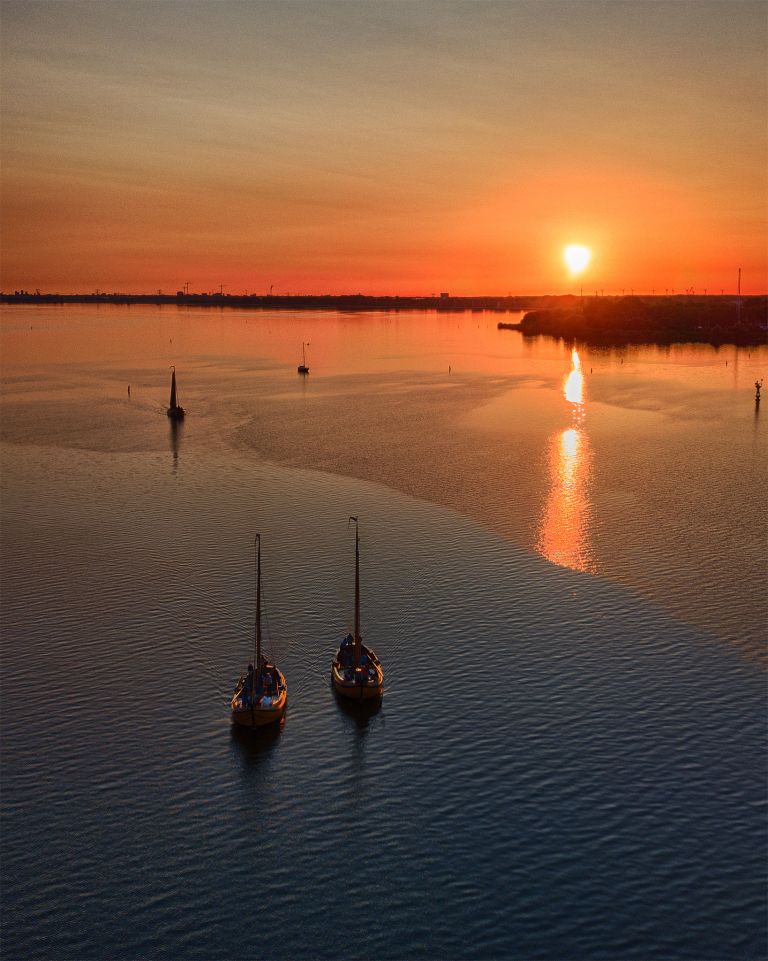 Sailing boats on lake Gooimeer during sunset