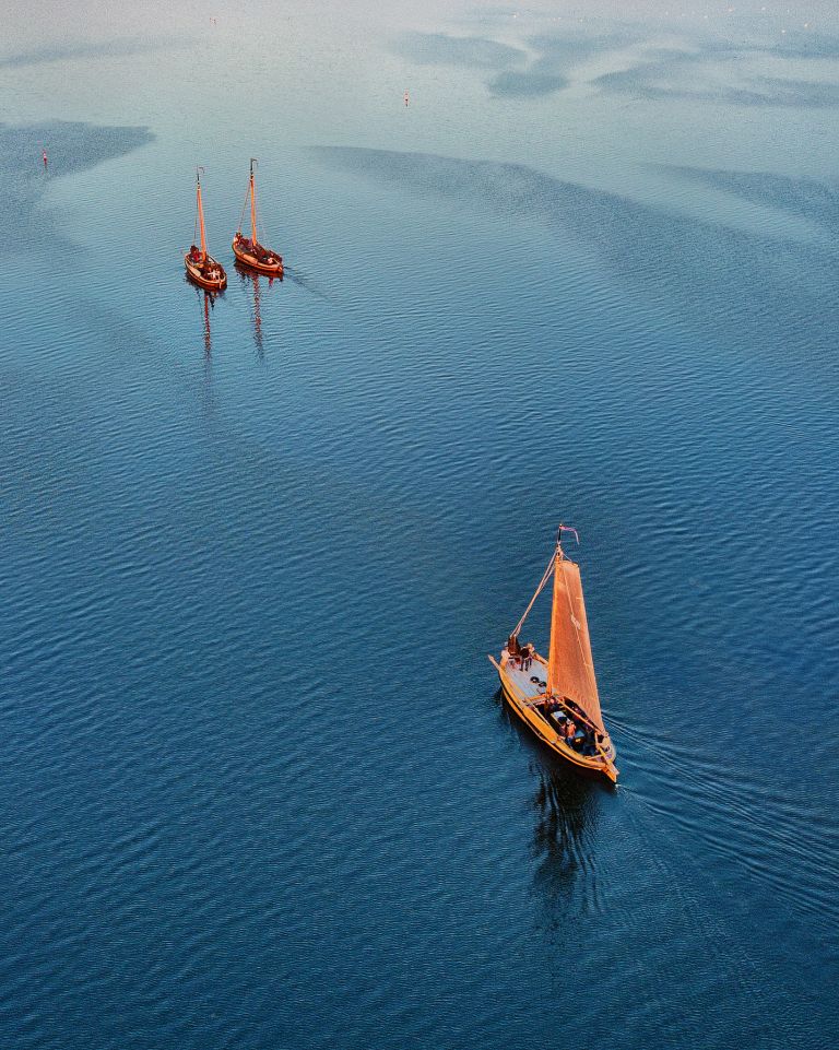 Sailing boats on lake Gooimeer during sunset