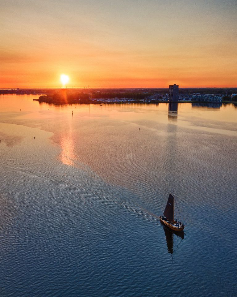 Sailing boat on lake Gooimeer during sunset