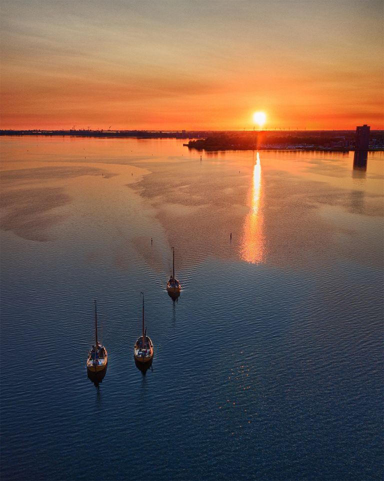 Sailing boats on lake Gooimeer during sunset