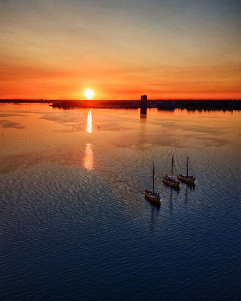 Sailing boats on lake Gooimeer during sunset