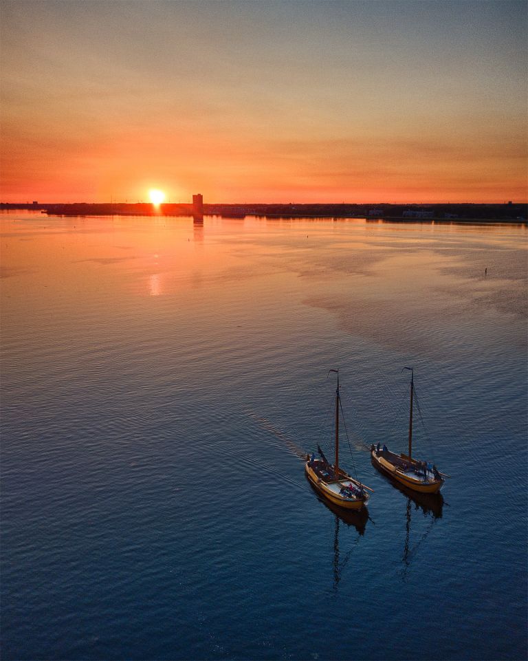 Sailing boats on lake Gooimeer during sunset