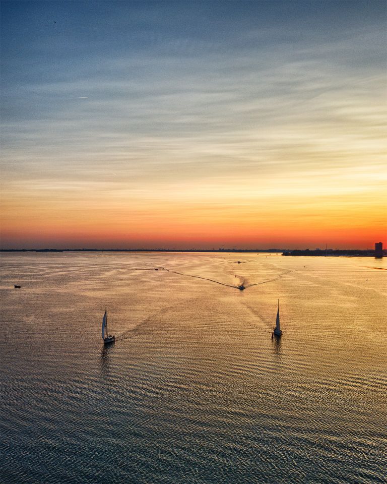Sailing boats on lake Gooimeer during sunset