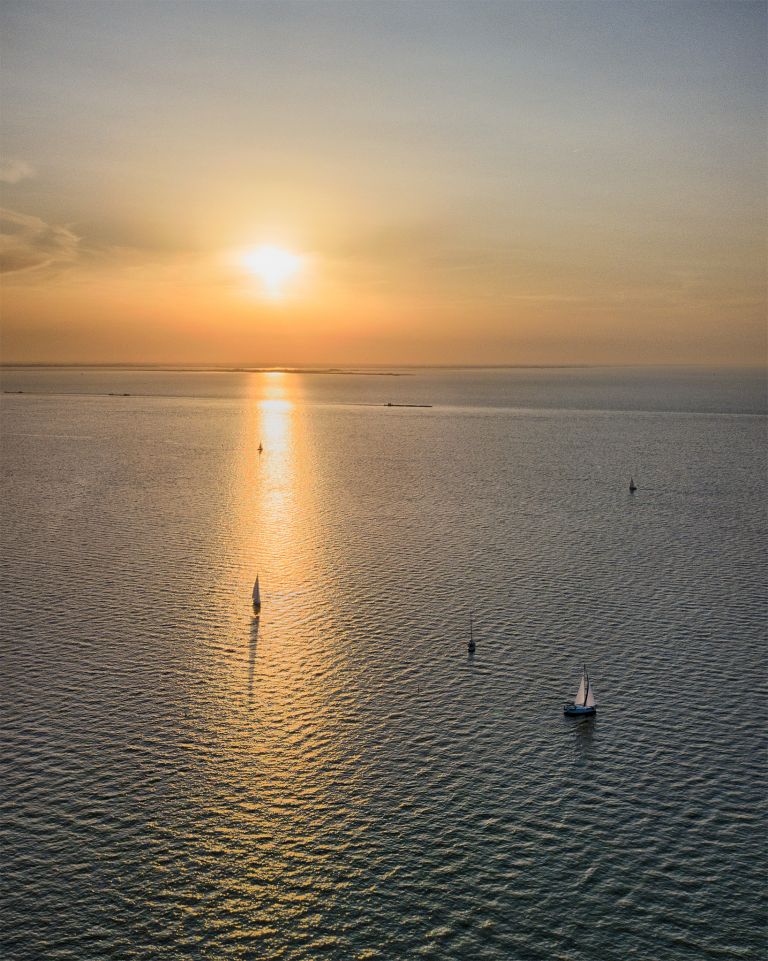 Boats sailing on lake Markermeer during sunset