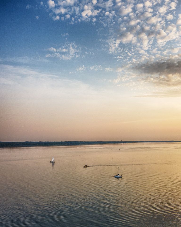 Sailing boats on lake Gooimeer during sunset